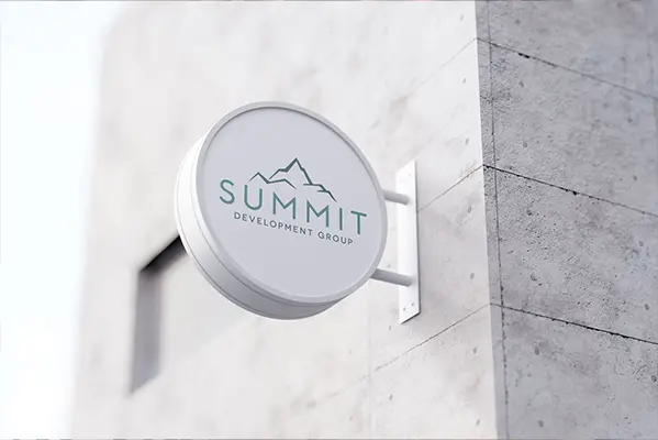 The Summit Development Group logo is on a round white sign, hanging on the side of a building.