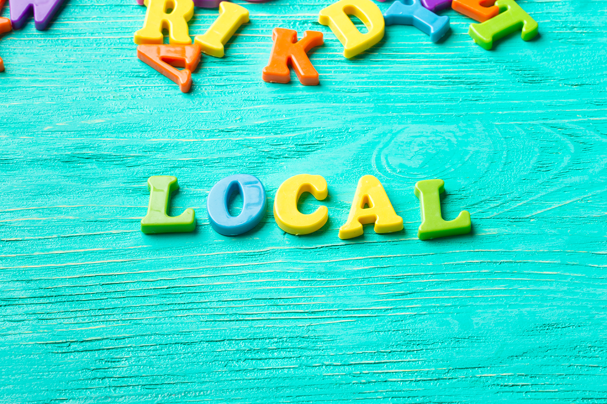 Colorful letter magnets spelling “local” on a wooden surface, representing local SEO marketing