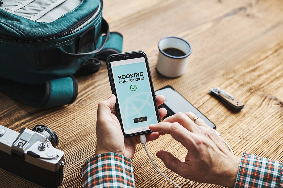Person using smartphone to confirm online booking for travel or service reservation