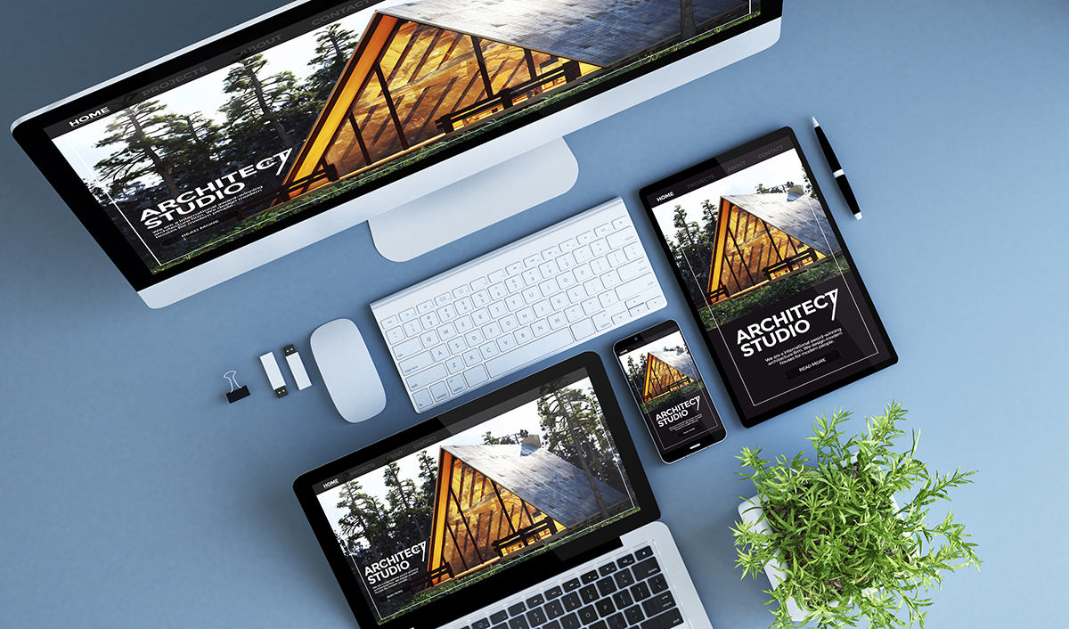 Responsive website design displayed across desktop, laptop, tablet, and smartphone screens on a desk.